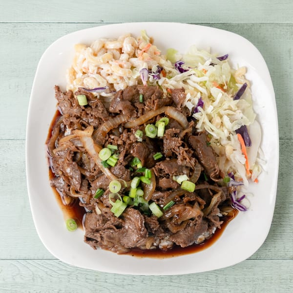 Hawaiian beef teriyaki plate with macaroni salad and coleslaw on a white plate.